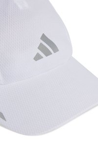 White sporty cap made of textured fabric. Features a curved brim and silver Adidas logo accents on the front and side.
