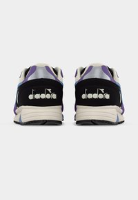 Τα αθλητικά παπούτσια Diadora διαθέτουν μαύρο και μοβ επάνω μέρος με ασημένιες λεπτομέρειες, μαλακή μπεζ σόλα και υφασμένο λαστιχένιο πέλμα για καλύτερη πρόσφυση.