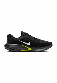 Czarny sportowy but z siateczkową cholewką, z białym logo Nike, zielonymi akcentami na podeszwie oraz zaokrąglonym kształtem dla wsparcia.