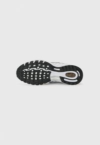 Biała podeszwa sneakerów z czarną gumową przyczepnością, z teksturowanym wzorem i widocznym logo marki. Lekka z elementami amortyzującymi.