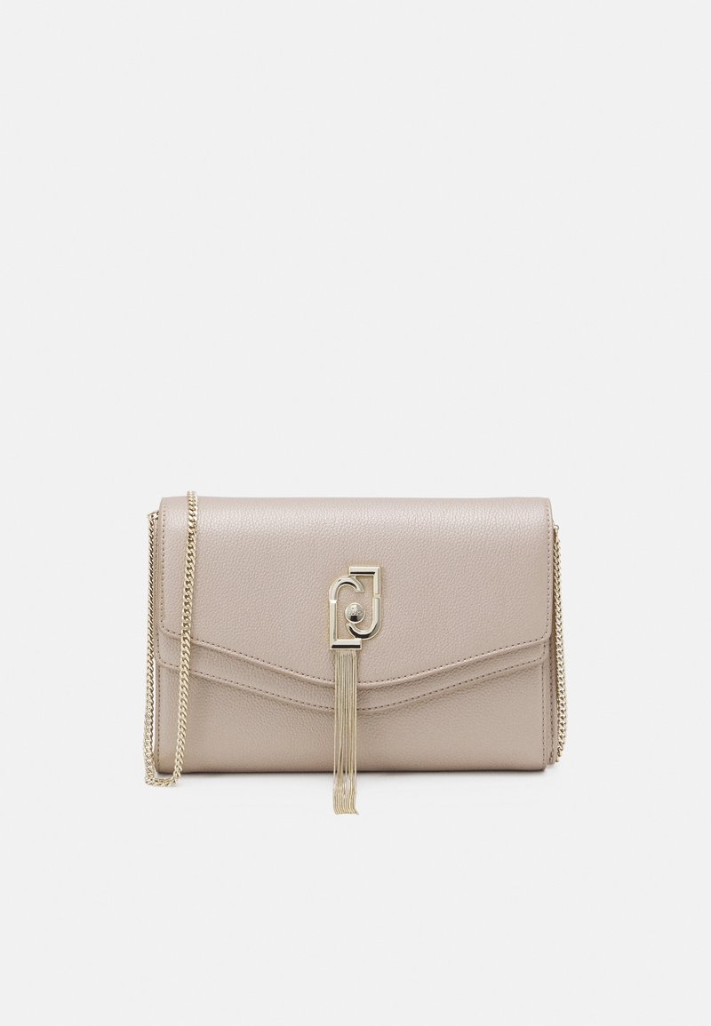 Sac à main en cuir beige avec une bandoulière chaîne, doté d'un rabat triangulaire et de ferrures dorées avec un détail pompon.