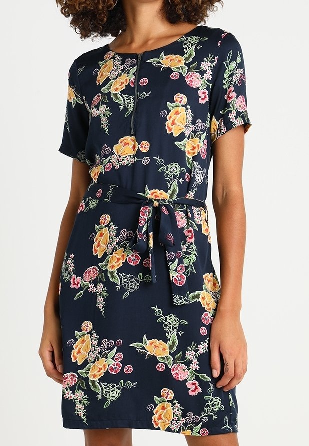 Robe florale marine à manches courtes, avec un détail de bouton et une taille nouée. Motifs floraux jaunes, roses et verts sur un fond sombre.