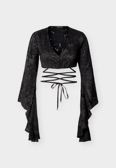 Μαύρο διαφανές cropped τοπ με μακριά φαρδιά μανίκια, μπροστινό τύλιγμα, λουλουδάτα σχέδια και κορδόνια μέσης που διασταυρώνονται με άκρες σε χρυσό χρώμα.