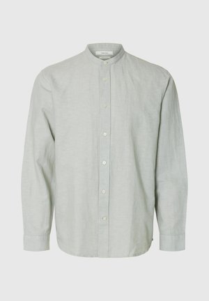 Šviesiai pilka ilgomis rankovėmis palaidinė su mandarinų apykakle ir septyniais mygtukais, rodoma ant paprasto fono.