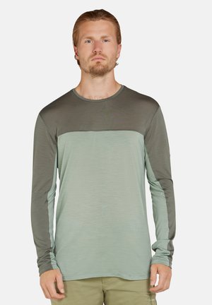 Langarmshirt in hellgrün und dunkelgrün, aus weichem Stoff. Verfügt über einen runden Halsausschnitt und ein kontrastierendes Paneeldesign auf der Brust.