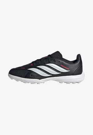Zapatilla de fútbol Adidas Predator en blanco y negro con tres franjas blancas, cierre de cordones y suela texturizada para tracción.