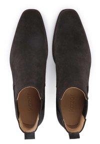 Bruna mockaankelboots med slät textur, fyrkantig tå och elastiska sidopaneler. Utrustade med en dragflik vid hälen och läderinteriör.