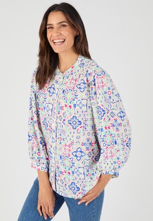 Kleurige blouse met een patroon, voorzien van een knoopsluiting aan de voorkant, een ronde halslijn en pofmouwen. De patronen omvatten geometrische ontwerpen in blauw, roze en groen.
