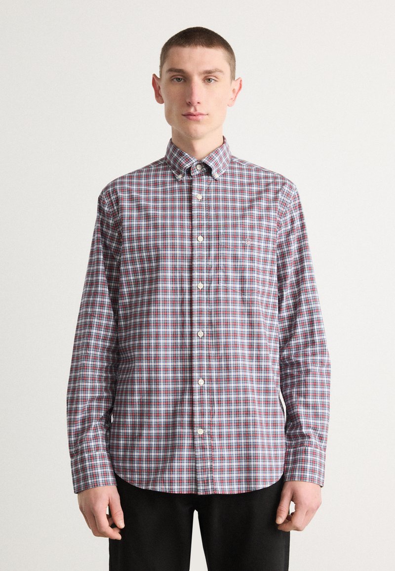 Camicia a maniche lunghe con bottoni in fantasia a quadri nei colori rosso, blu e bianco. Presenta un colletto con bottoni e una tasca sul petto.