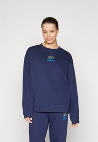 Felpa blu navy con colletto rotondo e maniche lunghe, dotata di un logo Lotto colorato sul petto e una vestibilità comoda.