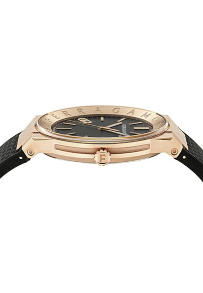 Puzdro hodiniek z ružového zlata s čiernym ciferníkom, logo Ferragamo na lunete a čierny textúrovaný remienok, bočný pohľad ukazuje korunku s iniciálom "F".