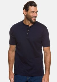 Polo a maniche corte collezione Henley in cotone di colore blu navy, con scollatura rotonda e patta con tre bottoni. Texture liscia e vestibilità casual.