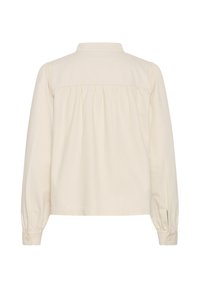 Chemise à manches longues couleur crème avec un empiècement et un détail de tissu froncé dans le dos, avec poignets boutonnés.