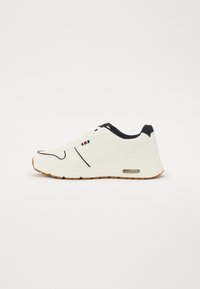 White athletic shoe with black accents, rubberized sole, and visible air cushioning. Features smooth texture and subtle design lines.
