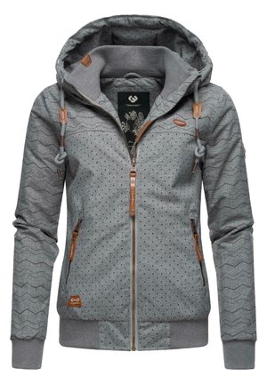 Sweat à capuche gris zippé avec un motif chevron texturé et des pois. Comprend une capuche, des poignets côtelés, et des accents en cuir tan sur les fermetures éclair.