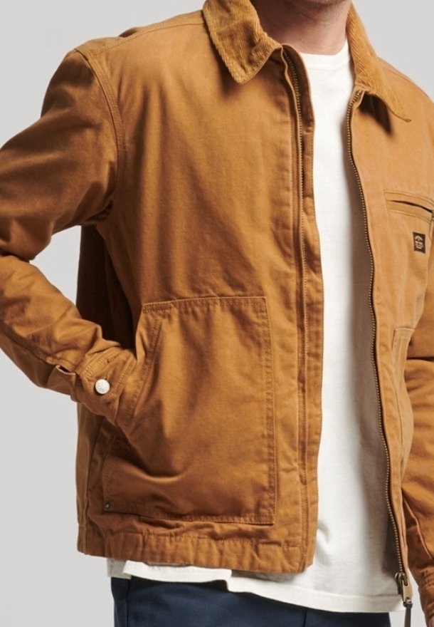 Bruine katoenen jas met een corduroy kraag, rits aan de voorkant en twee grote zijzakken. De stof heeft een licht getextureerd uiterlijk.