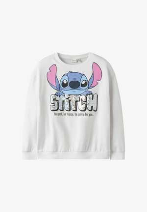 Sweat-shirt blanc avec un grand motif coloré du personnage Stitch, texte brillant "STITCH" et la phrase "sois bon, sois heureux, sois original, sois toi" en dessous.