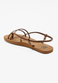 Braune Flip-Flops mit geflochtenen Riemen, flacher Sohle und strukturiertem Fußbett mit Logo. Glattes Material und konturierte Form für Komfort.