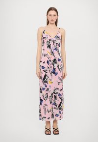 Ilga rožinė suknelė su juodais ir mėlynais abstrakčiais raštais, turinti gilią V formos iškirptę ir raištelių detalę priekyje. Dėvima su juodomis šlepetėmis.