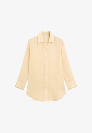 Jasnożółta, lniana koszula z długim rękawem, z kołnierzykiem, z zapięciem na guziki z przodu i zaokrąglonym dołem. Miękka tekstura bez widocznych wzorów lub akcentów.