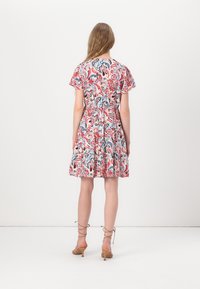 Dress featuring a colorful paisley pattern in red, blue, and white; short flutter sleeves; fitted waist; flared skirt; halter neckline.
