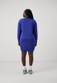 Βασιλικό μπλε φόρεμα πουκαμίσα με μακριά μανίκια, ριμπ μανσέτες και στρίφωμα. Διαθέτει λογότυπο στα μανίκια. Μαλακή υφή, άνετη εφαρμογή.