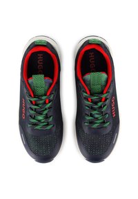 Baskets en maille bleu marine avec des accents verts et rouges, dotées d'une languette et de lacets à motifs, d'une doublure intérieure rembourrée et d'une semelle blanche contrastante.