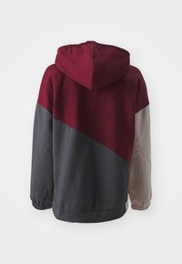 Sudadera con capucha que presenta un diseño de bloques de color diagonal en burdeos, gris y beige. Fabricada con material suave y con puños elásticos.