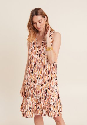 Mouwloze jurk met bloemenprint in oranje, roze en roomkleur. Geplooid ontwerp met een rucheszoom. Lichtgewicht stof. Ronde halslijn.