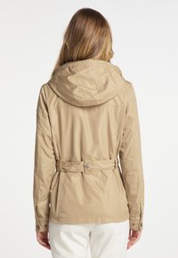 Beige waterdichte jas met een capuchon, een tailleriem en knoopmanchetten. Glad, lichtgewicht materiaal met een eenvoudig en functioneel ontwerp.