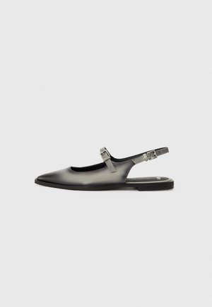 Schwarzer flacher Slingback-Schuh aus Leder mit zwei verstellbaren Schnallenriemen und spitzer Schuhspitze auf weißem Hintergrund.
