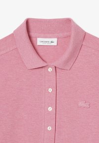 Maglietta polo rosa realizzata in tessuto texturizzato, con pattina a tre bottoni e logo sul lato sinistro. Design slim fit.