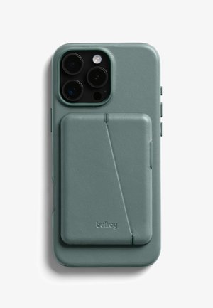 Custodia per telefono in pelle verde con finitura texturizzata, porta tessere sul retro, ritagli precisi per la fotocamera e i pulsanti laterali. Logo impresso in basso a destra.