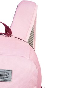 Roze stoffen rugzak met een gevoerde achterkant, verstelbare schouderbanden en een grijze logo patch. Heeft gaasaccenten voor ademend vermogen.