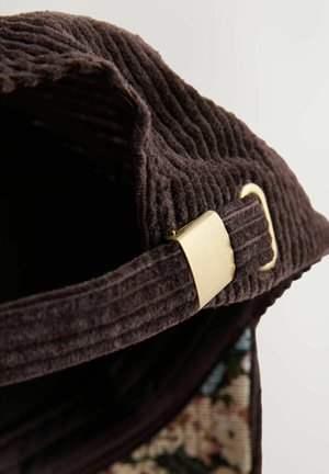 Sac en velours côtelé marron avec une surface texturée, doté d'une boucle métallique dorée et d'accents floraux sur le côté.
