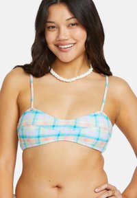 Pásikavý bikiny top v mnohých farbách s tenkými ramienkami; má jemnú, hladkú textúru v pastelových odtieňoch modrej, ružovej a zelenej.
