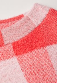Pletený svetr s kostkovaným vzorem v odstínech korálové a růžové. Měkká, texturová tkanina s kulatým výstřihem.