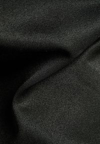 Tissu noir à la texture lisse, présentant un motif tissé et un léger éclat. Le matériau semble durable et polyvalent.