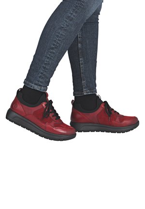 Rote Leder-Sneaker mit schwarzen Akzenten, ausgestattet mit einer strukturierten Oberfläche, runder Spitze, Schnürsenkeln und einer dicken schwarzen Gummisohle.