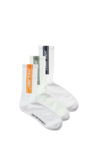 Drie paar witte katoenen sokken met geribbelde boord. Kenmerkt gekleurde strepen: oranje, groen en marineblauw met het merkgemerk. Tekst op de voet.