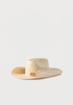 Jasnobeżowy, szerokokapeluszowy kapelusz z plecionego słomy z lekko zakrzywionym rondem i małym ozdobnym emblematem z jednej strony.