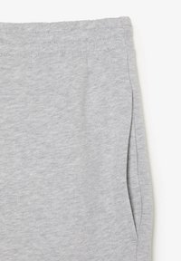 Gray sweatpants with a soft, textured finish. Features an elastic waistband and side pockets. Simple, casual design with no visible patterns.