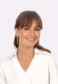 Orecchini a goccia argento con molteplici cristalli trasparenti, caratterizzati da un design a cascata. Modello che indossa una camicia bianca con colletto su uno sfondo neutro.