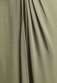 Olive green fabric with gathered pleats, featuring a soft, smooth texture and a subtle sheen. The material appears lightweight and flowy.