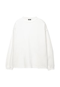 Sweatshirt blanc à manches longues en coton. Il présente un col rond, des épaules tombantes et des poignets côtelés. Texture lisse sans motifs.