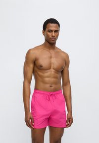 Ροζ μαγιό σορτς με ελαστική μέση και κορδόνι, με ελαφριά, απαλή υφή και κλασικό σχεδιασμό σορτς.