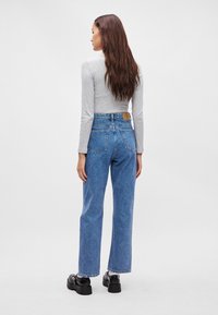 Jeans z wysokim stanem w niebieskim denimu o prostym kroju nogawki, z skórzaną łatą na pasku i tylnymi kieszeniami z klapami.