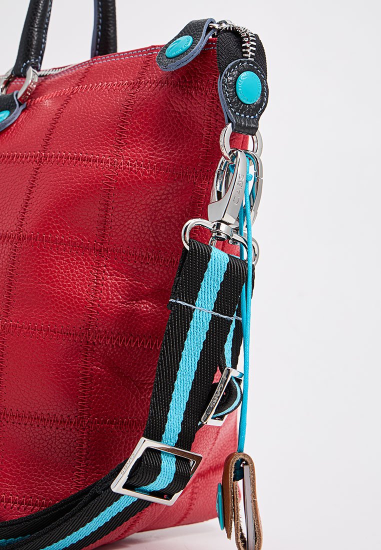 Bolso de hombro de cuero rojo con un acabado texturizado, que presenta una correa de hombro de rayas en negro y turquesa y detalles en hardware plateado.