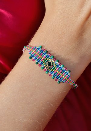 Bracelet tissé coloré avec des perles turquoise, rose et verte. Élément central décoratif avec une pierre noire. Fermoir ajustable.