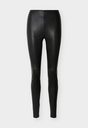 Μαύροι ψηλόμεσοι, εφαρμοστοί κολάν από συνθετικό δέρμα με λεία υφή, παρουσιάζονται σε απλό ανοιχτόγκρι φόντο.